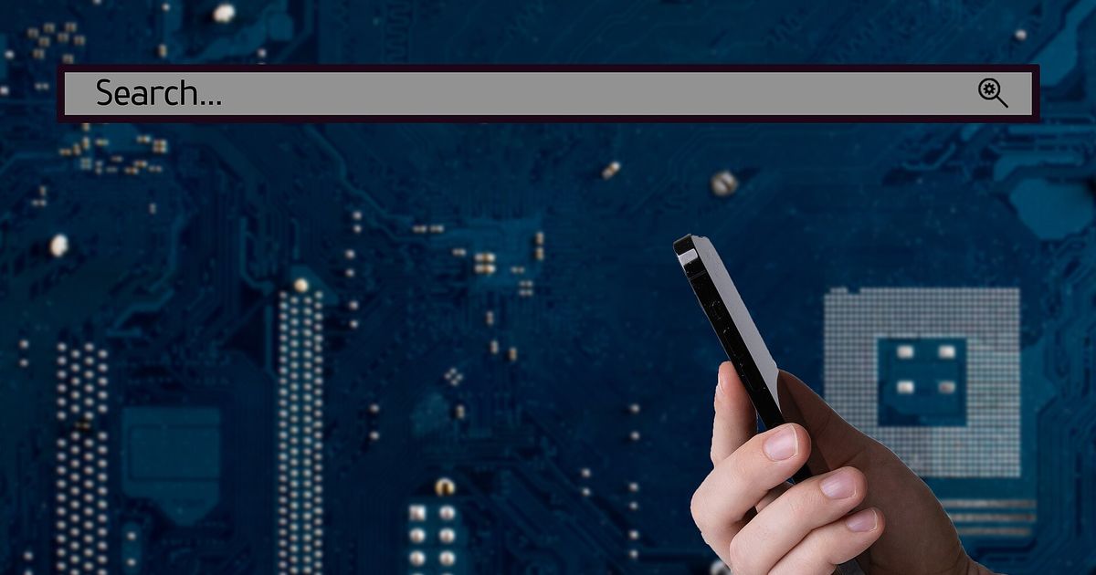 A hand holding a smartphone in front of a blurred blue circuit board, below a large empty search bar that reads "Search..."