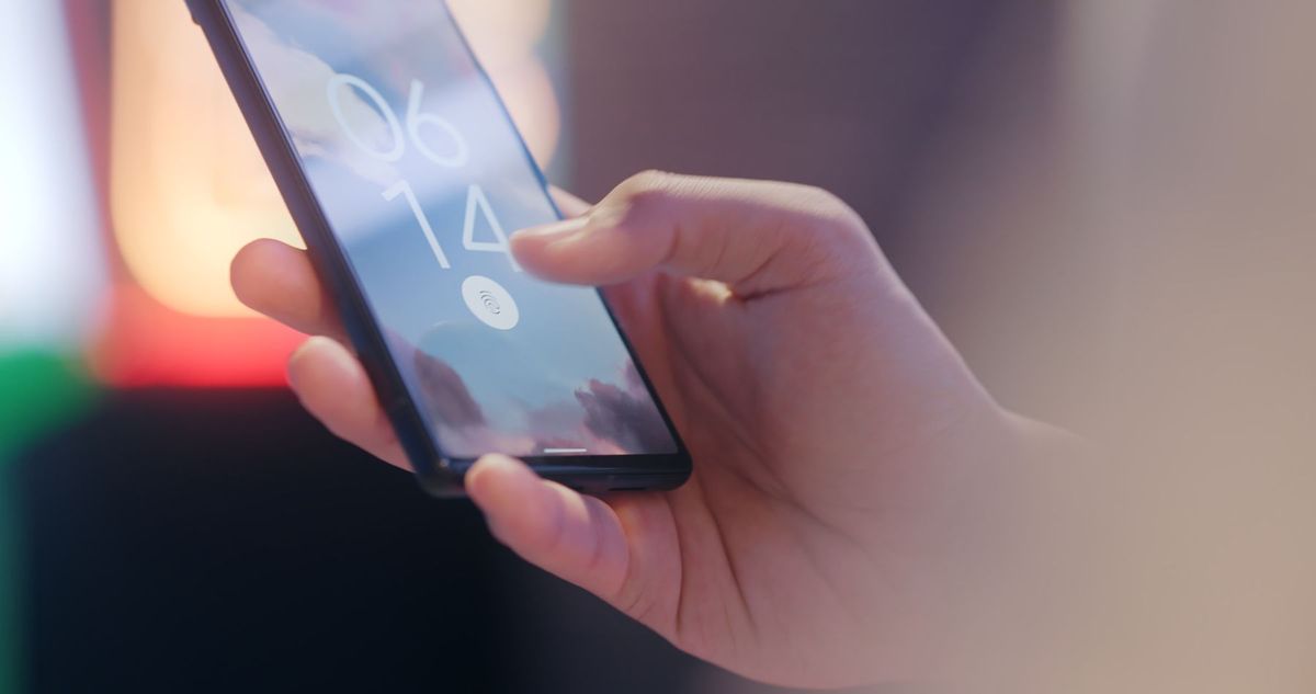 A hand unlocking a smartphone whose lock screen shows the time 06:14