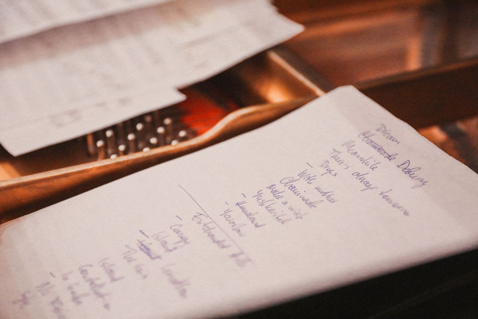 A close-up of a handwritten checklist on paper in warm light