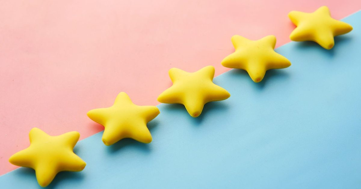 Five glossy yellow stars in a diagonal row across a pink and light blue background