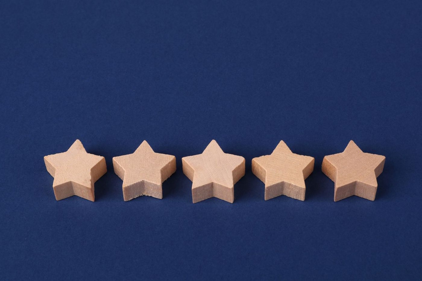 Five wooden stars in a row on a blue background