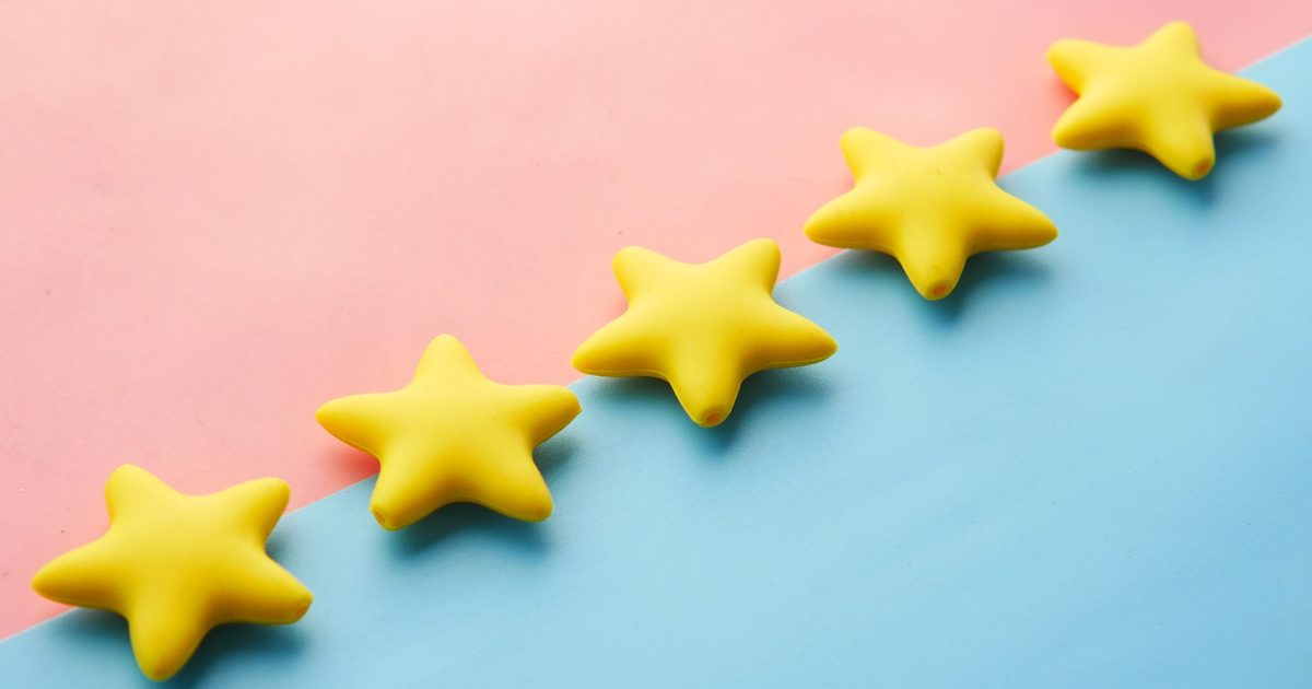 Five yellow rubber stars in a diagonal row across a pink and light blue background