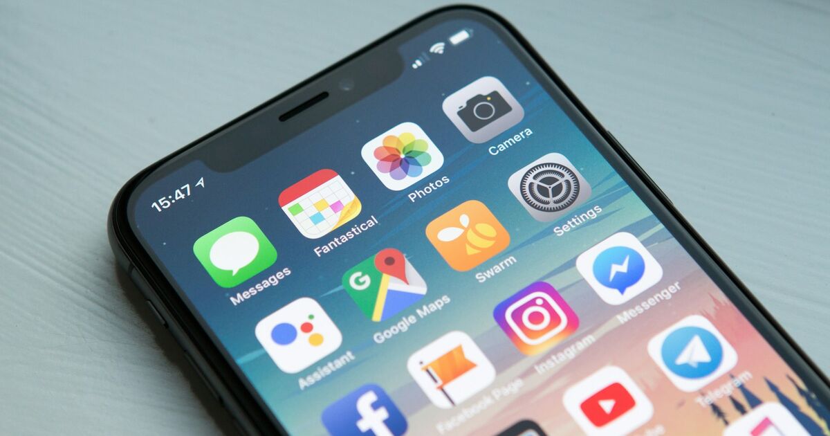 Close-up of an iPhone home screen at an angle, showing app icons such as Messages, Photos, Camera, Google Maps and Instagram